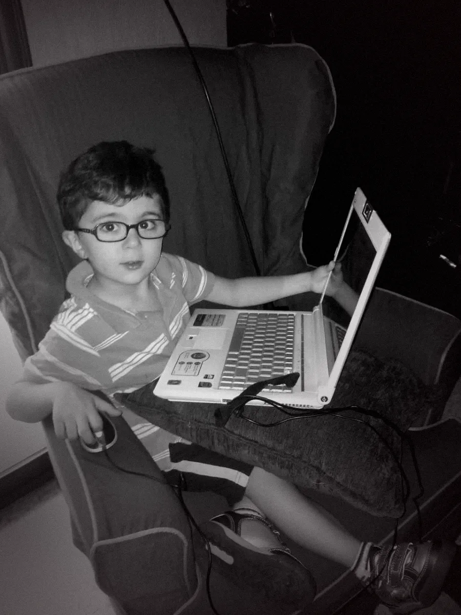 Zaven Jooharian as a child, sitting with a laptop